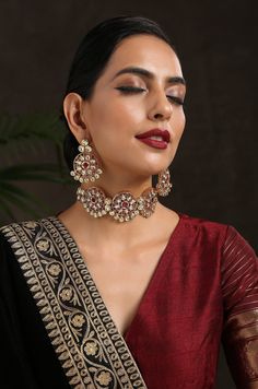 This exquisite design features a rich palette and beautiful kundan work. The top choker part is encrusted with red stones and dangling from it are several kundan units embellished with pearl trinkets. Necklace Closure - Adjustable Dori Earrings Closure - Push Back Style Tip - Being a strong supporter of the intersection of classic and contemporary, we love designs that are contemporary yet boast hints of traditional charm. This choker can be a great pair for traditional sarees, indo-wedstern dre Temple Jewelry With Zari Work For Party, Diwali Party Jewelry With Zari Work, Red Kundan Traditional Wear With Stone Work, Red Chandbali Temple Necklace With Stone Work, Red Kundan Chandbalis Bollywood Style, Red Meenakari Chandbali Necklaces, Red Bollywood Kundan Necklace For Party, Red Meenakari Chandbali Necklace, Red Bollywood Kundan Chandbalis