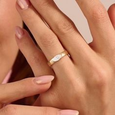 a close up of a person wearing a ring on their finger and holding the other hand