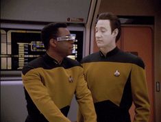 two men in star trek uniforms standing next to each other