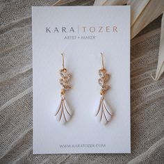 Our handmade scalloped bridal dangles are designed with marquis shaped CZ stones that descend into an elegant charm crafted from polymer clay. Hooks are made from high quality 14K gold filled material. One of our most loved styles for brides.  KARA | TOZER offers handmade clay and gold jewelry for everyday and special occasions. All of our everyday styles are inspired by neutral tones that will pair beautifully with any outfit. Items are restocked weekly but feel free to send a message if a cert White Elegant Dangle Teardrop Earrings, White Elegant Teardrop Dangle Earrings, White Dangle Teardrop Earrings With Elegant Design, Dainty White Dangle Bridal Earrings, White Teardrop Earrings With Elegant Design For Gifts, Delicate Dangle Earrings For Bridal Shower, Dainty White Teardrop Bridal Earrings, White Dangle Earrings For Wedding Gift, White Teardrop Earrings With Elegant Design For Wedding