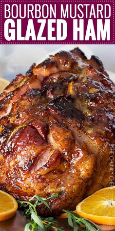 a ham with oranges and herbs on a plate next to some lemons,