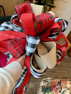 a person is holding a red and black bow on top of some burlocks