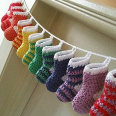 knitted baby booties hanging on a clothesline in front of a window sill