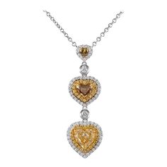 Exquisite heart shape fancy color diamond drop pendant necklace with double diamond halos, by Alexander Beverly Hills. 3 heart shape diamonds ranging from Fancy Yellow to Fancy Brown color grade, 3.54ct. Complimented by 0.78 carats of round brilliant diamond Fancy Yellow and white diamonds. Prong set in 18k white and yellow gold, 11.06 grams, and 16 inches. Accommodated with an up-to-date digital appraisal by a GIA G.G. once purchased, upon request. Please contact us with any questions. Diamond Drop Pendant, Diamond Drop Necklace, Double Diamond, Drop Pendant Necklace, Heart Shaped Diamond, Grade 3, Fancy Color Diamonds, Drop Necklace, Brilliant Diamond