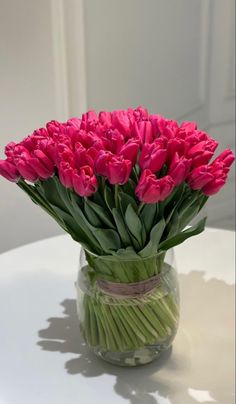 a vase filled with pink flowers sitting on top of a table