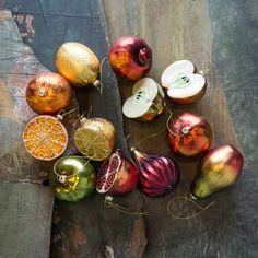 an assortment of christmas ornaments sitting on top of a piece of plywood with string