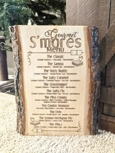 a wooden sign that says gourmet smores menu on the side of a tree