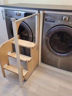 a washer and dryer sitting next to each other in a room with wooden steps