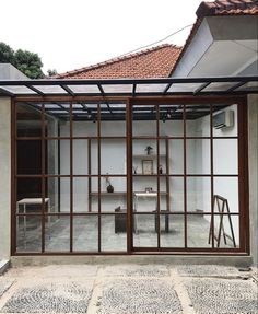 an open glass door leading into a room with a table and chairs in the background