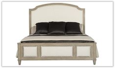 an image of a bed that is made up and has black pillows on the headboard