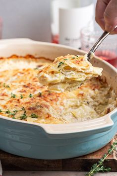 a person scooping some food out of a casserole dish with a spoon