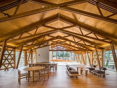 the inside of a wooden building with tables and benches in it's center area