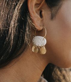 Our Charu collection combines cruelty free, ethically sourced bones featuring hand carved lace filigree work and shiny, gold finish brass elements in exquisite, boho chic designs. These bone earrings are expertly handcrafted by artisans in Old Delhi. Artisans utilize traditional Indian jewelry craft tools and techniques to skillfully transform local and upcycled materials into modern designs. The intricate hand worked filigree on this piece is a testament to their mastery of the craft, passed on White Bohemian Earrings With Intricate Design, White Bohemian Filigree Earrings, White Brass Jewelry For Festival, White Bohemian Brass Earrings, Brass Filigree Chandelier Dangle Earrings, Brass Filigree Dangle Hoop Earrings, Bohemian Brass Jewelry With Fair Trade Details, Bohemian Brass Jewelry Fair Trade, Bohemian Fair Trade Brass Jewelry