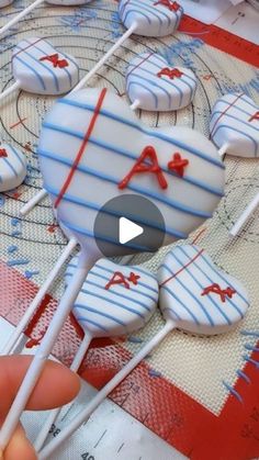 a person is holding some lollipops with blue and white icing on them