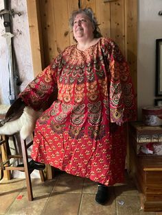 This caftan is made of screen printed India cotton fabric in bright red with multi colored design. It is one size fits most just like the good old Medieval days.  Shaping is accomplished with a belt.  Photo #6 is the same size and pattern (different fabric) on a med woman, belted with Kurdish pants.  Photo #1 is the exact same tunic on a size 3 XLarge.  Photo 2 is the same tunic on an XL man. Measurements: chest measurement is 64 inches  sleeve end, across shoulders to opposite sleeve end 70 inches  length from shoulder to hem is 48 inches   Preshrunk from the makers there is a slight bit of residual shrinkage.  Machine wash and dry - or just get rained on, it dries quickly! I have been wearing these for years as my night wear.  Very durable and easy care.  I use them at camping events lik Traditional Patterned Cotton Kaftan For Festivals, Cotton Kaftan With Traditional Patterns For Festivals, Cotton Hippie Kaftan For Festival, Hippie Cotton Kaftan For Festival, Long Sleeve Cotton Kaftan For Festivals, Bohemian Cotton Kaftan With Traditional Patterns, Red Floral Print Tunic Kaftan, Red Bohemian Cotton Kaftan, Red Cotton Bohemian Kaftan