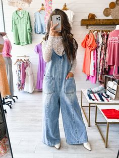 A washed denim overall featuring a V neckline, large front pockets, wide leg, plunging back and adjustable straps. 100% Cotton Runs true to size. Model is wearing a small. 34” bust, 26” waist, 35” hips, 5’6”) Waist Hips Inseam Length Small 40 inches 42 inches 27 inches 59 inches Medium 42 inches 44 inches 27 inches 59 inches Large 44 inches 46 inches 27 inches 60 inches We measure each item from side seam to side seam, on a flat surface. Please consider the fabric content of each item, as fabric Overall Dress Fall Outfit, Flowy Overalls Outfit, Denim And Lace Outfits, Western Overalls Outfit, Blue Jean Overalls Outfits, Oversized Overalls Outfit, White And Denim Outfits, Fall Overall Outfits, 90s Overalls Outfit