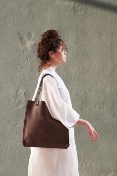 "This is a minimalist tote leather handbag, yet very elegant and classy, with high quality finishing outside and inside. Perfect for all shopping purposes, or as a laptop bag. ** SIZE:  15\"x15\"(38cmx38cm)  ** COLOR:  Available in Brown. Other colors Upon Request. ** SHIPPING POLICY:  All deliveries within 7-10 business days. In case of any delay due to the current pandemic, we will notify you ahead of time. 25 dollar flat-rate \"Door to Door\" delivery worldwide where  delivery is available. I Minimalist Tote Bag With Smooth Grain, Minimalist Smooth Grain Tote Bag, Minimalist Smooth Grain Shoulder Bag For Shopping, Minimalist Brown Bag With Smooth Grain, Minimalist Smooth Grain Tote Shoulder Bag, Minimalist Leather Shoulder Bag, Minimalist Double Handle Shoulder Bag With Leather Lining, Minimalist Bags With Leather Handles, Minimalist Square Leather Bag