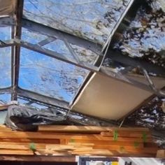 the inside of a building that is being constructed with wooden boards and glass roofing