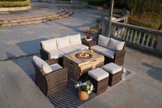 an outdoor fire pit surrounded by wicker furniture