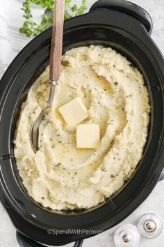 mashed potatoes in a crock pot with butter and parsley