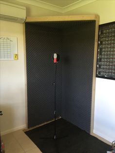 an empty room with a microphone on the floor in front of a large screen wall