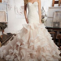 a woman in a wedding dress posing for the camera