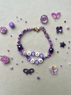 a bracelet with beads and charms that read dear mom on it, surrounded by butterflies