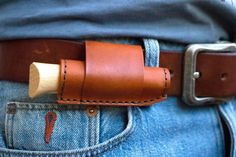 a leather belt with a wooden buckle on it's back pocket in someone's jeans