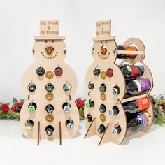 two wooden snowmen with wine bottles in them