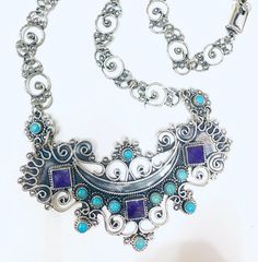 Baroque-style silver necklace with natural turquoise and amethyst. 📌Solid .925 sterling silver. 📌Handmade in Taxco, Mexico. 📌Includes earrings. This piece of jewelry is made in our workshops in Taxco de Alarcón, Mexico shows the beauty and master of the silver tradition and techniques in Taxco. With your purchase you support a small business 🙌🏻 Bohemian Sterling Silver Dangle Necklaces, Bohemian Sterling Silver Gemstone Necklace, Bohemian Sterling Silver Gemstone Necklaces, Elegant Silver Turquoise Necklace, Bohemian Jewelry With Sterling Silver Clasp, Elegant Sterling Silver Turquoise Pendant Necklace, Elegant Sterling Silver Turquoise Dangle Necklace, Bohemian Sterling Silver Gemstone Jewelry, Sterling Silver Purple Jewelry With Intricate Design