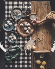 a table topped with plates and bowls filled with food next to a wooden cutting board