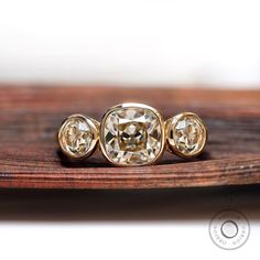 three diamond rings sitting on top of a wooden table