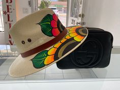 Individually hand painted artisanal fedora hats. Each hat is meticulously hand painted by an artist. Each hat is unique and full of colors. Made by artists from Mexico the hats represent the beauty of Mexico.  (A) This hat is light beige with sunflower design. Vibrant colors with pink, fusia, yellow, orange, green, gold, brown and more.  (B) This hat is light army green with sunflower design. Vibrant colors with pink, red, yellow, orange, green, gold, brown and more.  This hat is great for vacation in Tulum, Burning Man, Coachella, Beaches, or just brunching locally!  Made out of light canvas with air holes on top of hat for breathable and cool comfort. Size: Medium has elastic band on inside and can fit most heads Inner is 8" Length and 6.5" Width Hat is apprx 13.5" Length and 12.5" Width Hat Painting, Hat Bands, Painted Hats, Fedora Hats, Lighted Canvas, Spring Hill, Sunflower Design, Hat Band, Fedora Hat