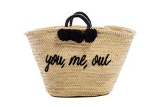 a woven basket with the words you me out written on it and a black handle