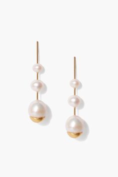 two pearl drop earrings on a white background