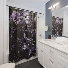 a bathroom with a skull shower curtain next to a sink