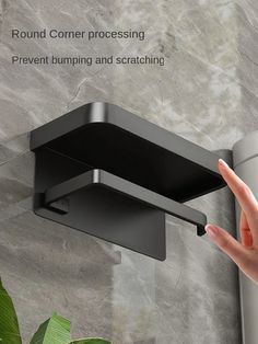 a hand is touching the corner of a wall mounted shower faucet