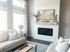 a living room filled with furniture and a fire place in front of a large window