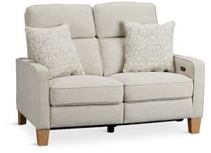 the reclining loveseat has two pillows on it's arms and legs