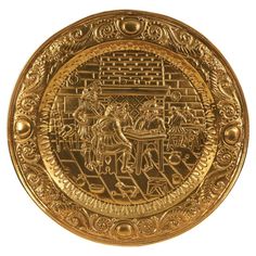 a gold plate with an image of people and animals on it