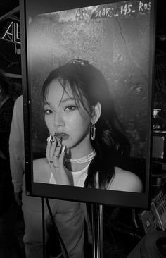 a black and white photo of a woman eating food in front of a television screen