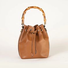 Monzac. Vegan Leather. Bucket Bag With Bamboo Top Handle And Removable Crossbody Strap. Cactus Leather. Cognac Bucket Bag For On-the-go, Chic Bucket Bag With Bamboo Handle For Daily Use, Elegant Cognac Bucket Bag For On-the-go, Everyday Chic Bucket Bag With Bamboo Handle, Chic Bucket Bag With Bamboo Handle For Everyday, Chic Everyday Bucket Bag With Bamboo Handle, Chic Hobo Bag With Bamboo Handle, Brown Satchel With Bamboo Handle For Everyday Use, Chic Bucket Bag With Bamboo Handle