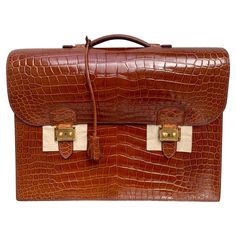 The Sac à Depeche briefcase from Hermès of Paris is one of the famed French luxury goods house's most coveted and exclusive items. This is a "Horeshoe Stamp" and this version carries a 6 year waiting list and is available by special order only for $90,000+. The ultimate unisex business accessory, the elegant model has long been a favorite of aristocrats, royalty, the international jet set and heads of state. One of a kind and only one in existence. This Hermes is bathed in a glazed Meil Brown He Mens Dress Hats, Italian Suit, Double Lock, French Luxury, Crocodile Bags, Briefcase For Men, Waiting List, Vintage Hermes, Travel Jewelry Case