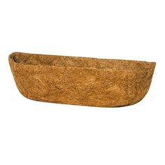 a wooden bowl that is sitting on a white surface and has some grass in it