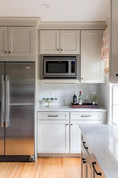 a kitchen with white cabinets and stainless steel appliances