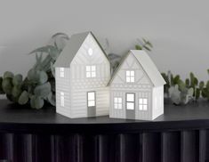 two paper houses sitting on top of a table