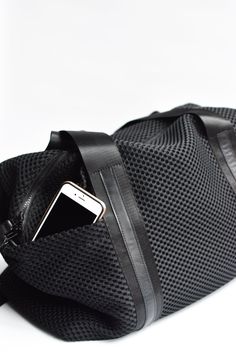 This mesh duffel bag has loads of pockets and interior organization. The perfect bag for daily workouts and weekend adventures. Black mesh with our signature leather trim and handles, finished off with a leather bottom, removable shoulder strap and easy to clean glossy liner. Content:- Mesh- Leather- Imported Size:- Width: 18" - Height: 12"- Depth: 7"- Handle Drop: 10" Sporty Weekender Bag With Zipper Pocket For Travel, Sporty Tote Duffle Bag For Daily Use, Sporty Large Capacity Duffle Bag For On-the-go, Sporty Duffle Tote Bag For Daily Use, Sporty Travel Bag With Zipper Pocket For Daily Use, Sporty Nylon Weekender Bag For Everyday Use, Sporty Weekender Bag For Travel, Large Capacity Nylon Tote Duffle Bag, Daily Use Mesh Shoulder Bag With Mesh Lining