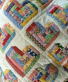 a close up of a colorful quilt on a cell phone screen with the caption, log cabin hearts quilt