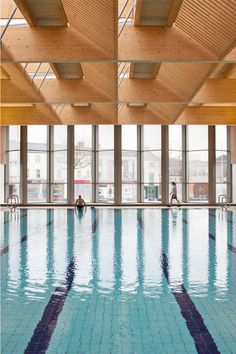 an indoor swimming pool surrounded by large windows