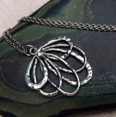 This is such a fun and unique silver flower necklace.  It is modern and whimsical in it’s detail and design.  Perfect for everyday wear and very versatile in style.  The pendant measures 1 1/4” long by 1” wide and hangs from a simple 18” stainless steel necklace chain.  I have matching earrings in my shop, if you would like the whole set.  Here is the link........ https://etsy.me/2A7CZDF Thanks for stopping by!  Please take a moment and visit the rest of my Etsy shop.  I have many more unique je Bohemian Sterling Silver Flower Necklace, Silver Necklace With Nature-inspired Flower Charm, Silver Nature-inspired Necklace With Flower Charm, Nature-inspired Silver Flower Necklace With Charm, Unique Nickel-free Necklace With Flower Pendant, Unique Nickel-free Flower Pendant Necklace, Adjustable Silver Bohemian Flower Necklace, Bohemian Silver Flower Pendant Necklace, Nature-inspired Silver Metal Necklace